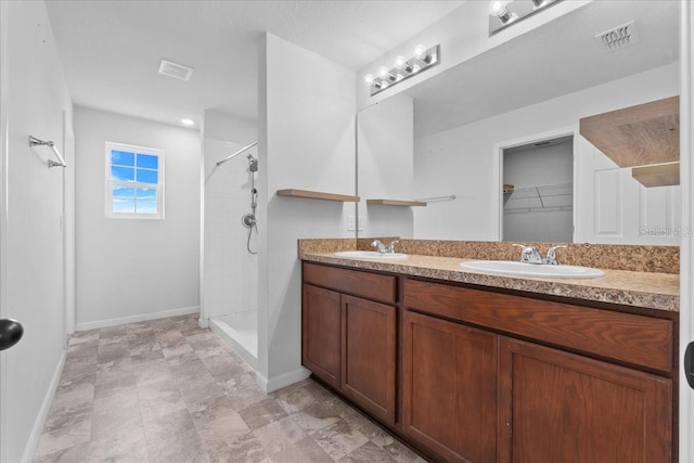 bathroom featuring vanity and tiled shower