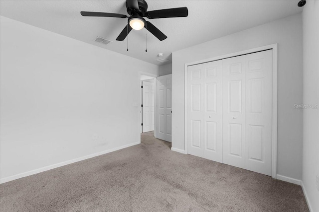 unfurnished bedroom with carpet floors, a closet, and ceiling fan