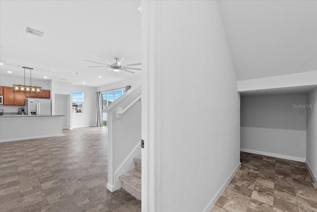 stairs featuring ceiling fan