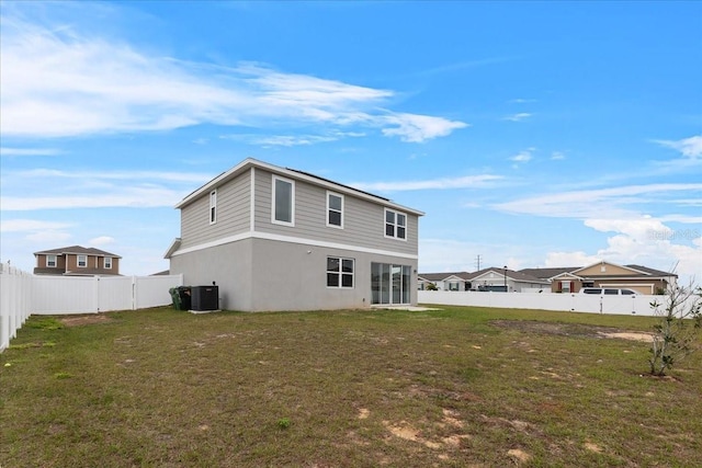 rear view of property featuring a yard and central AC unit