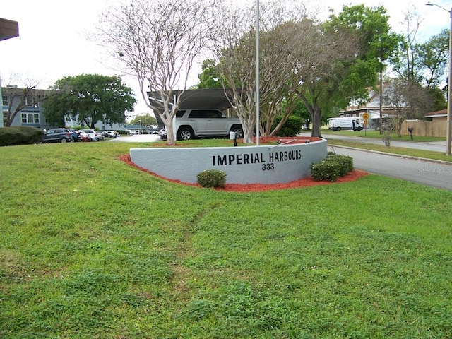 community / neighborhood sign featuring a yard