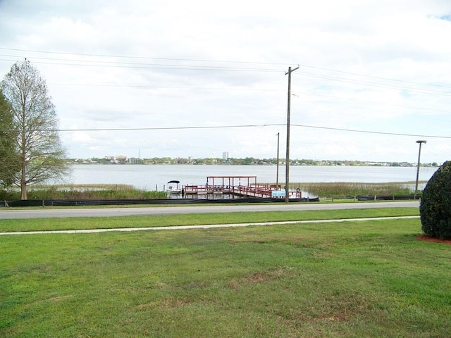 dock area with a lawn and a water view