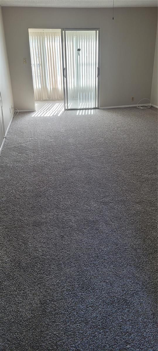 carpeted spare room with baseboards