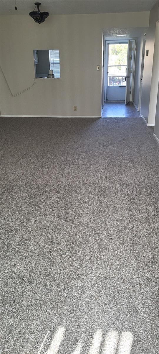 carpeted spare room featuring baseboards