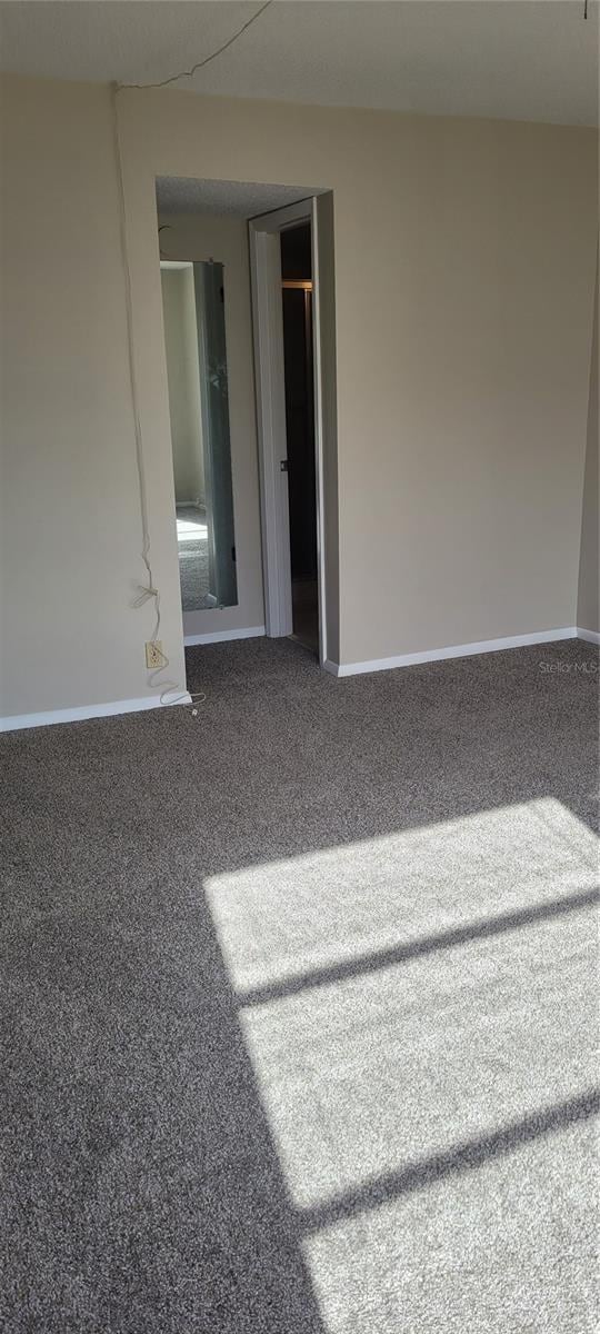 carpeted spare room with baseboards