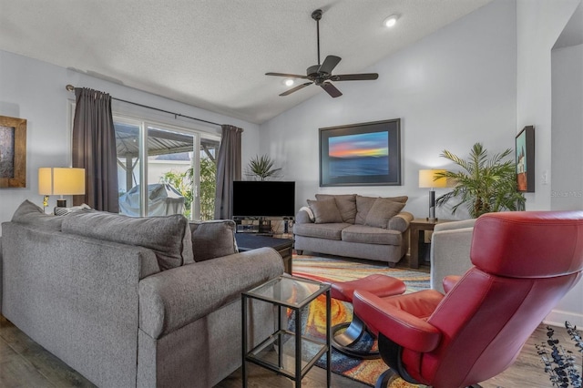 living room with vaulted ceiling, ceiling fan, a textured ceiling, and hardwood / wood-style flooring