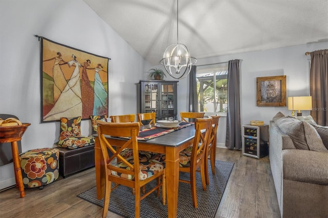 dining space featuring wood-type flooring, vaulted ceiling, and a chandelier