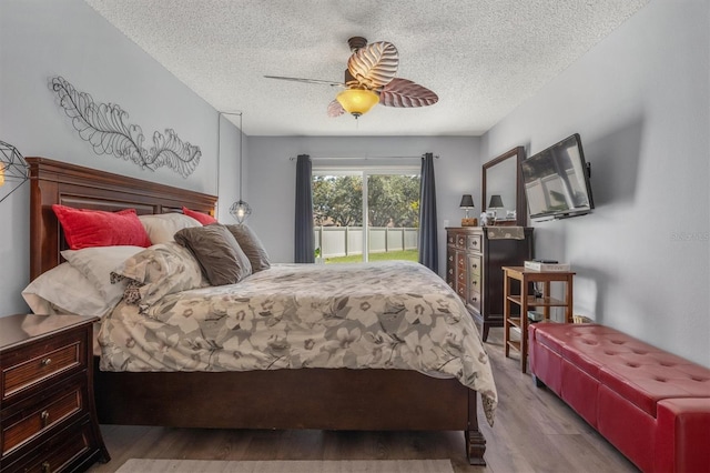 bedroom with a textured ceiling, ceiling fan, and light hardwood / wood-style flooring