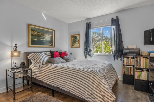 bedroom with wood-type flooring and a textured ceiling