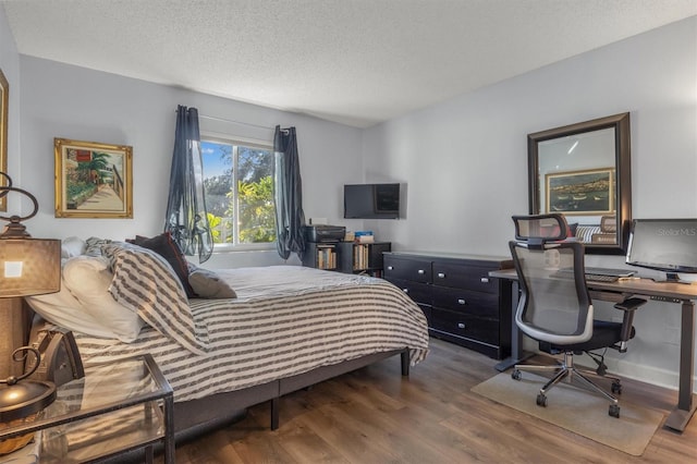 bedroom featuring dark wood-type flooring and a textured ceiling