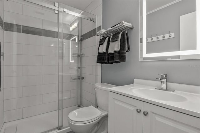 bathroom with a shower with shower door, toilet, vanity, and crown molding