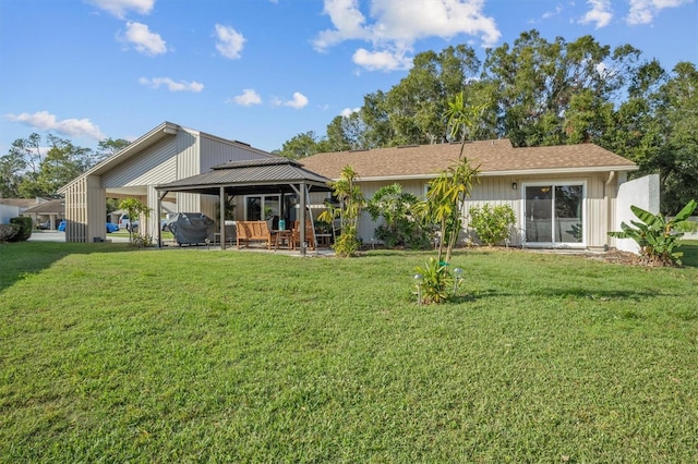 rear view of house featuring a gazebo and a lawn