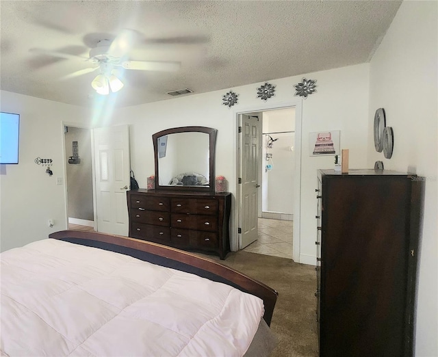 carpeted bedroom with ceiling fan and a textured ceiling