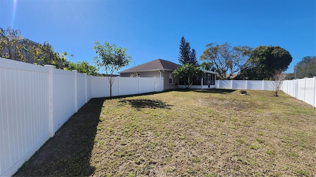 view of yard featuring a fenced backyard and a sunroom