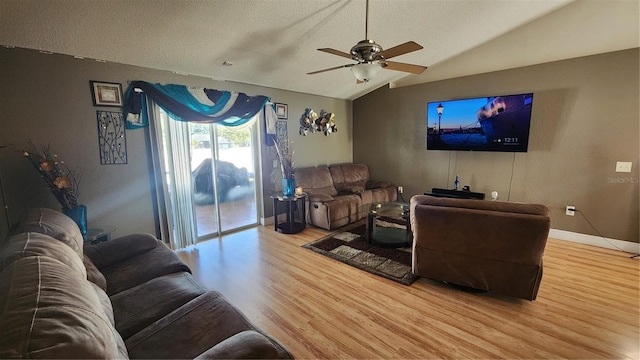 living room featuring hardwood / wood-style flooring, ceiling fan, lofted ceiling, and a textured ceiling