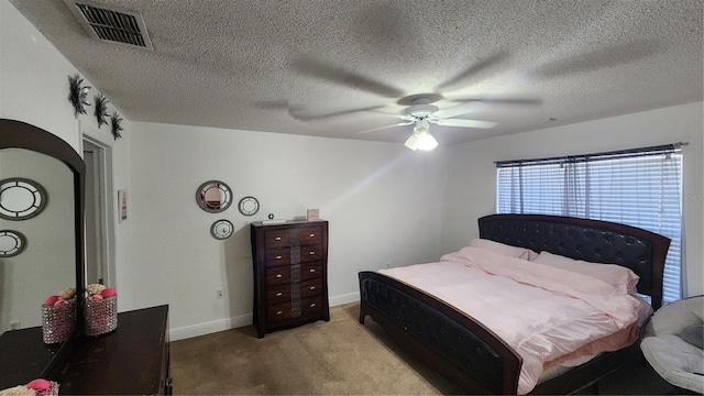 bedroom featuring light colored carpet, a textured ceiling, and ceiling fan