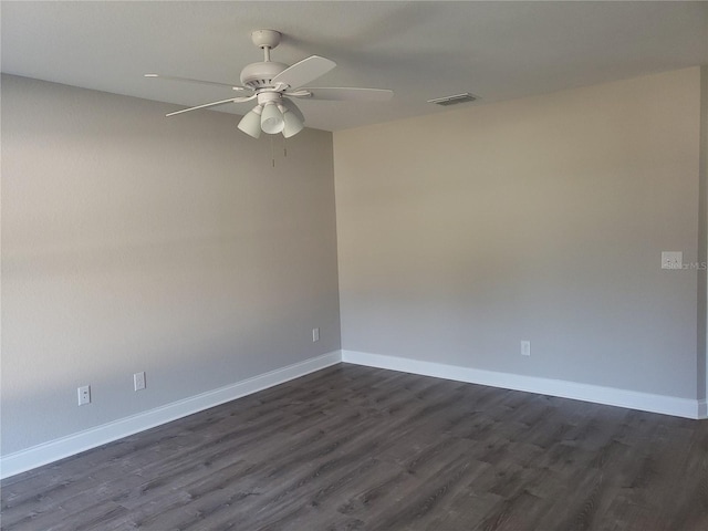 spare room featuring dark wood-type flooring and ceiling fan