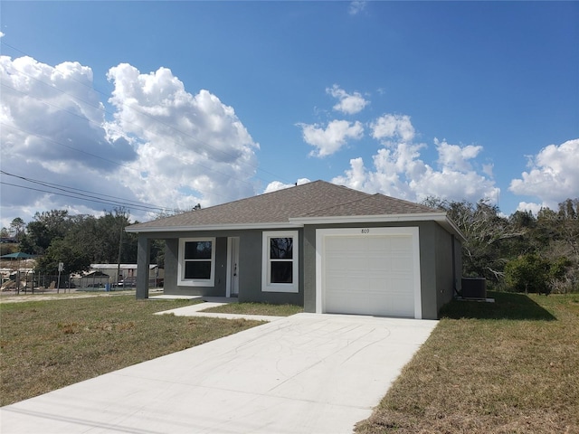 view of front of property featuring a garage, a front yard, and central air condition unit