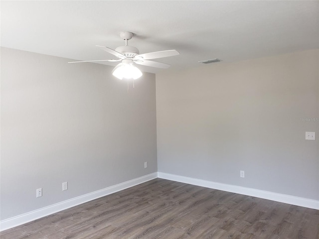 empty room with ceiling fan and dark hardwood / wood-style flooring