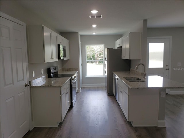 kitchen featuring appliances with stainless steel finishes, sink, white cabinets, and light stone counters