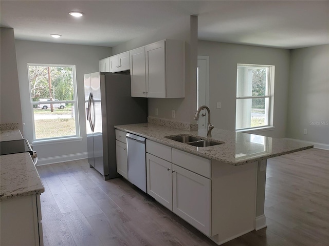 kitchen featuring light stone countertops, appliances with stainless steel finishes, sink, and white cabinets