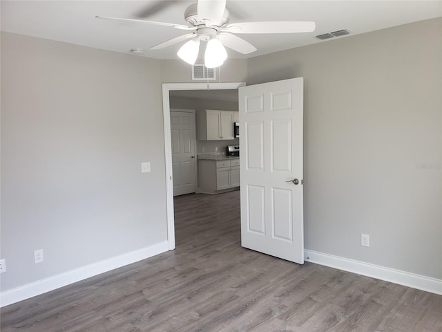 spare room with ceiling fan and light wood-type flooring