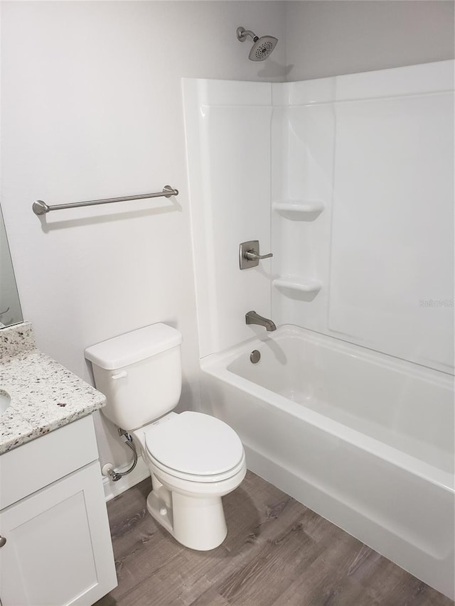 full bathroom with vanity, hardwood / wood-style flooring, shower / washtub combination, and toilet