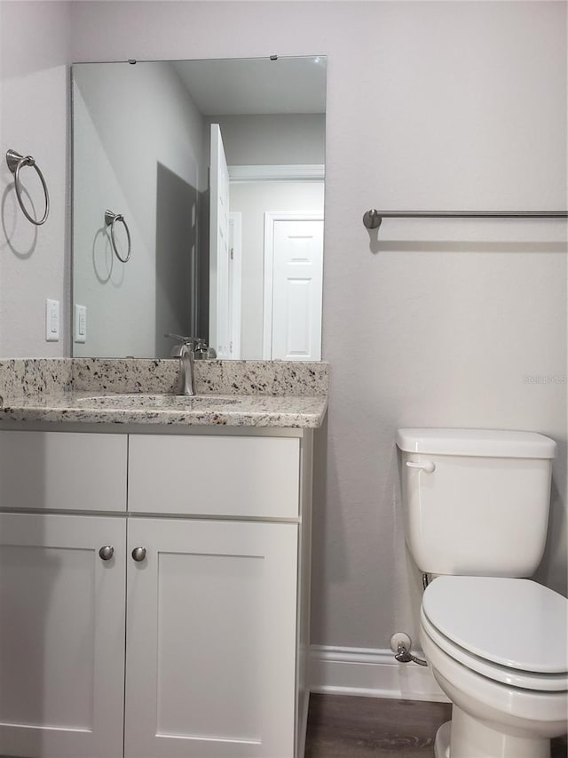 bathroom with vanity, wood-type flooring, and toilet