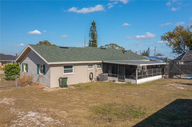 back of property featuring cooling unit, a yard, and a sunroom