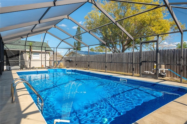 view of pool with a patio area and glass enclosure