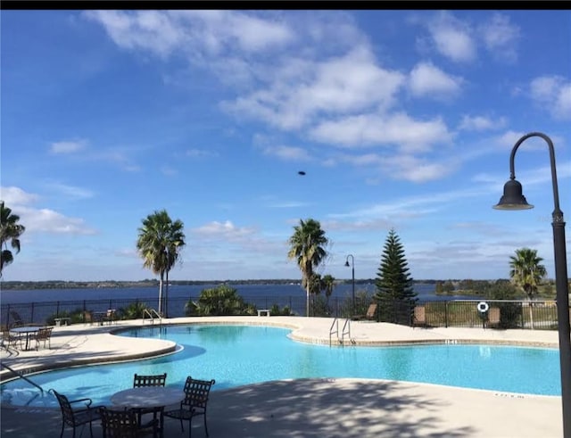 view of pool with a water view and a patio area