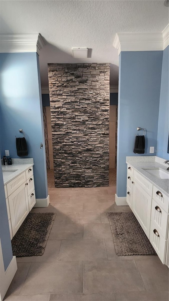 bathroom with sink, walk in shower, ornamental molding, and a textured ceiling