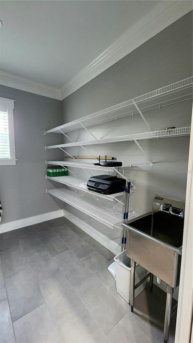 interior space with tile patterned floors, crown molding, and sink