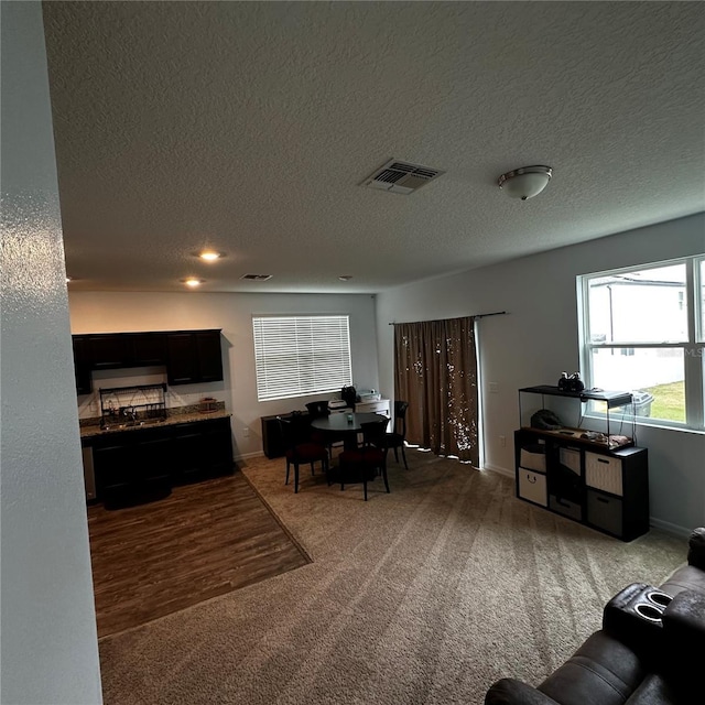 living room with a textured ceiling and carpet