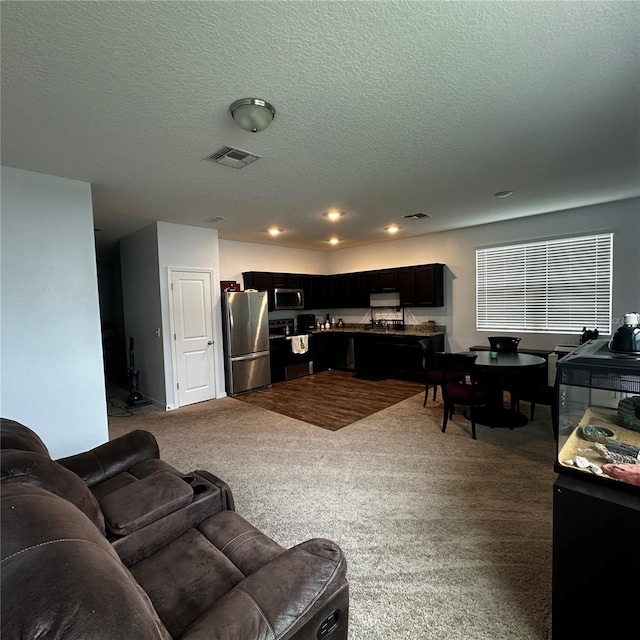 living room featuring a textured ceiling and carpet flooring