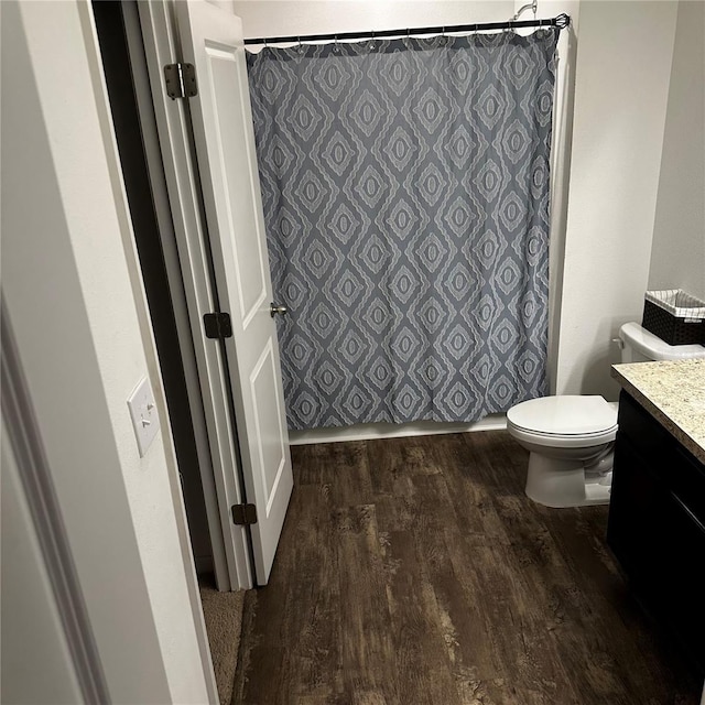 bathroom featuring toilet, vanity, and hardwood / wood-style floors