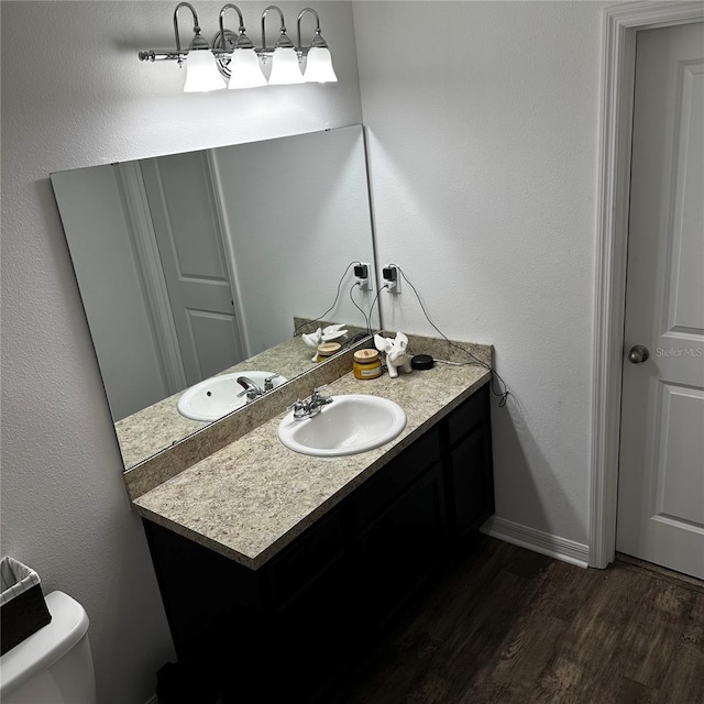 bathroom with toilet, wood-type flooring, and vanity