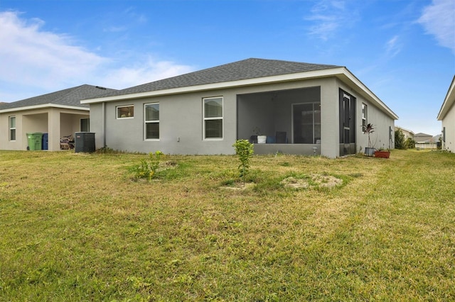 rear view of property featuring a lawn, central AC, and a sunroom