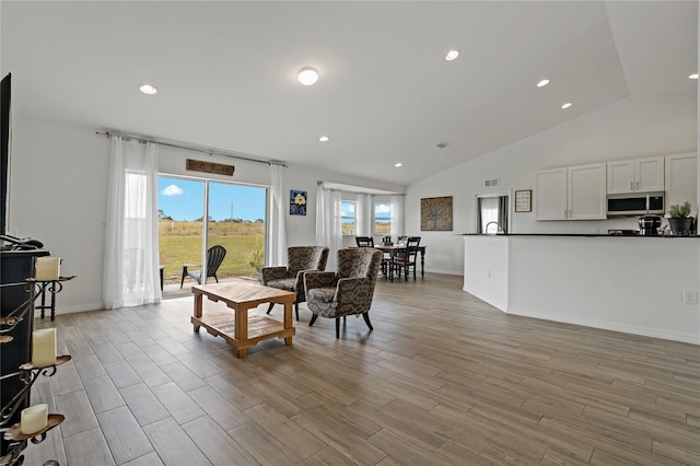 living room with sink and vaulted ceiling