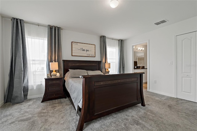 bedroom featuring light carpet and connected bathroom