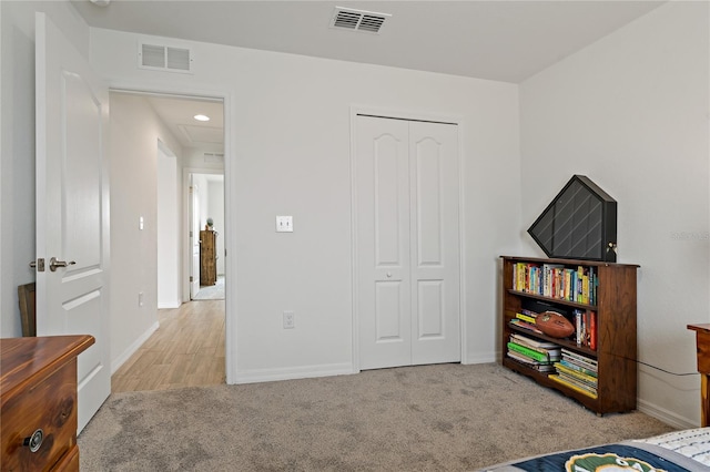 bedroom featuring light colored carpet and a closet