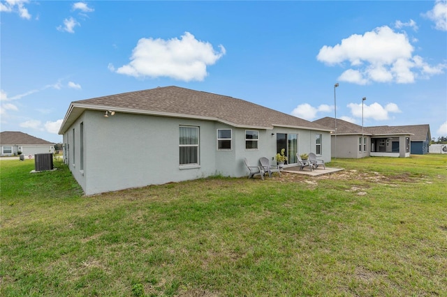 back of house with central AC, a yard, and a patio area