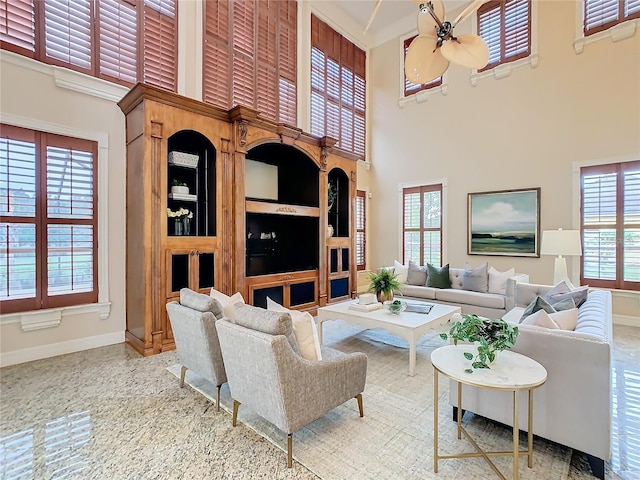 living room with ceiling fan, a high ceiling, and a wealth of natural light