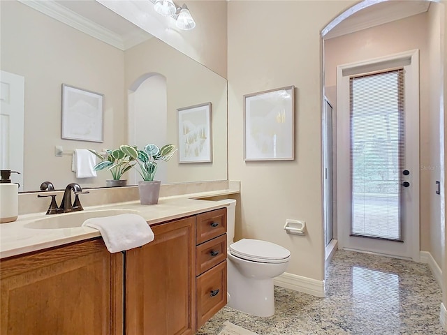 bathroom featuring toilet, vanity, crown molding, and a shower with shower door