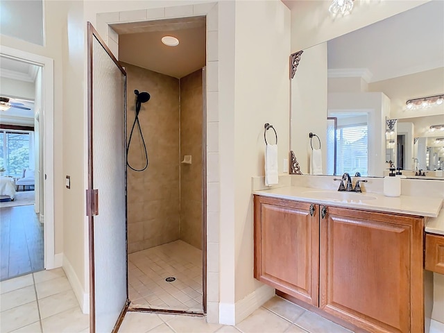 bathroom with vanity, tile patterned flooring, tiled shower, and ornamental molding