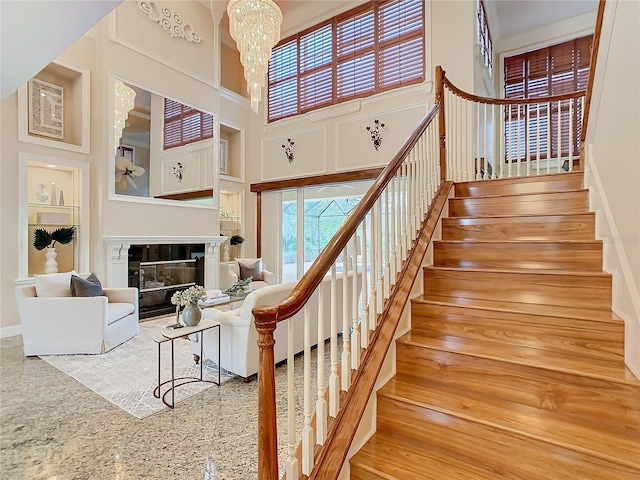 staircase with a towering ceiling and a chandelier