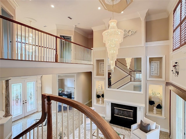 interior space with ornamental molding, a healthy amount of sunlight, french doors, and a notable chandelier