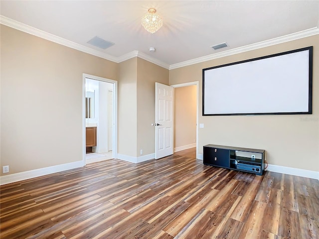 cinema room featuring dark wood-type flooring, crown molding, and an inviting chandelier