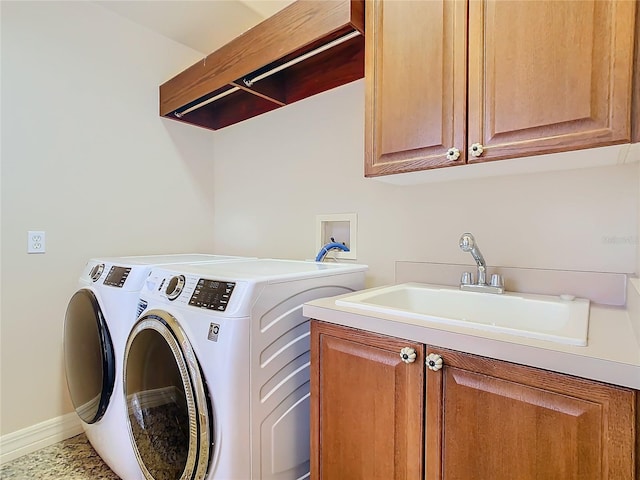 washroom featuring cabinets, sink, and washing machine and dryer