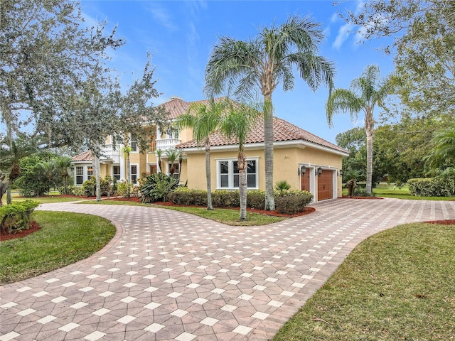 mediterranean / spanish-style house featuring a front lawn and a garage